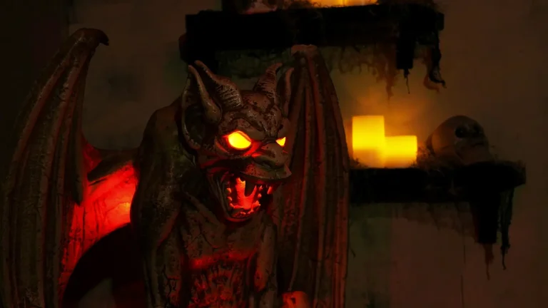 Gargoyle prop with glowing red eyes in a dark room