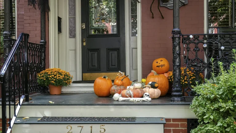 Front porch steps decorated with pumpkins, gourds and mums
