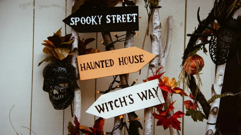 Wooden direction signs reading Spooky Street, Haunted House and Witch’s Way
