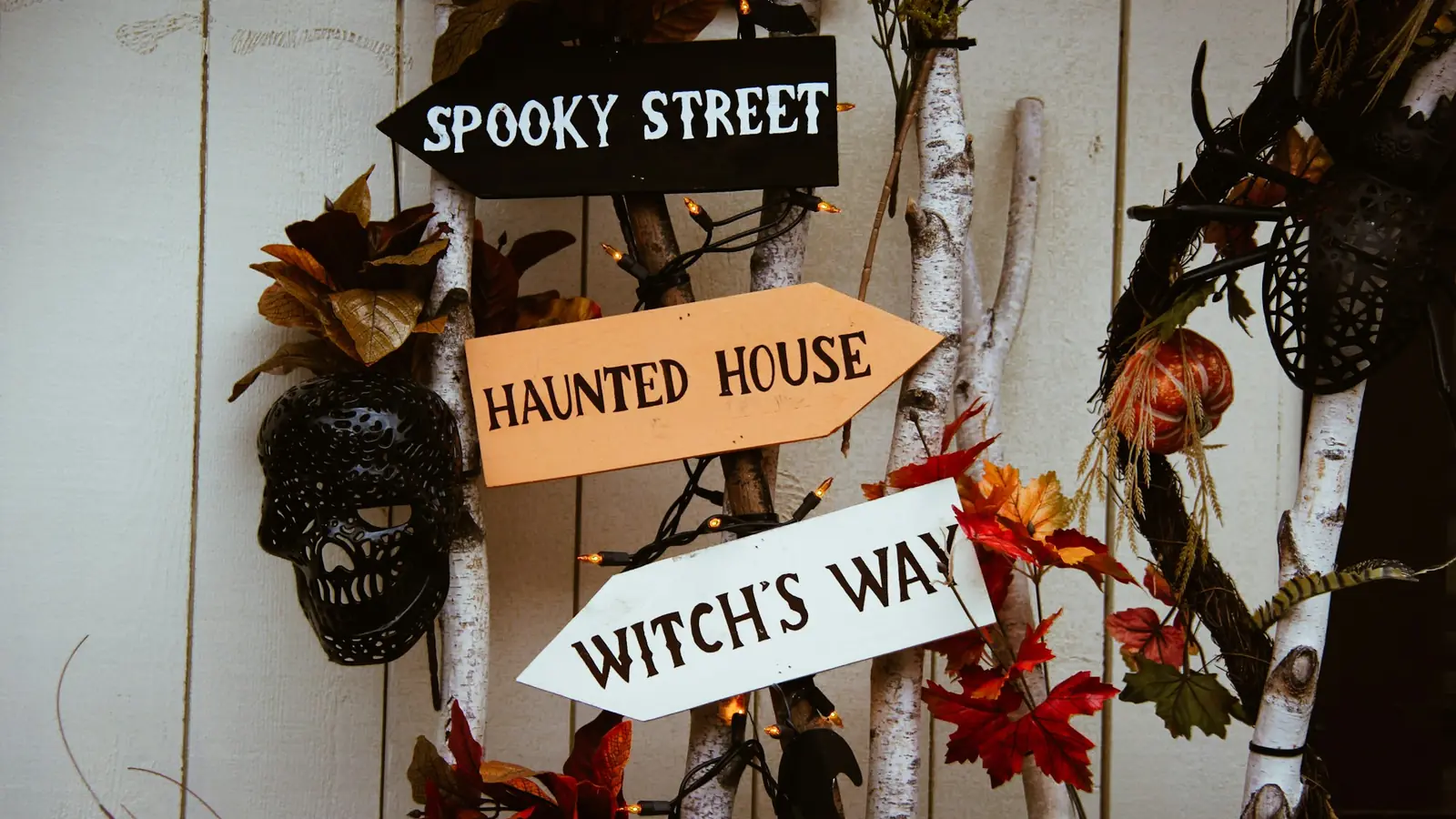 Wooden direction signs reading Spooky Street, Haunted House and Witch’s Way